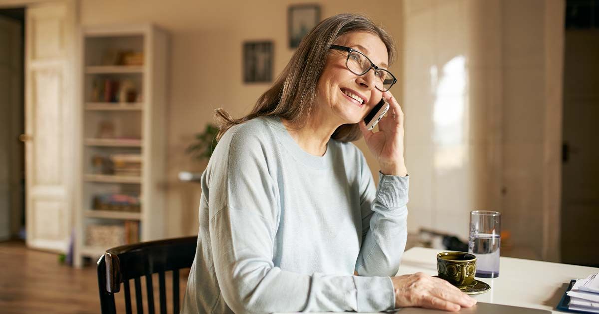 Woman sitting at desk, on a phone call.