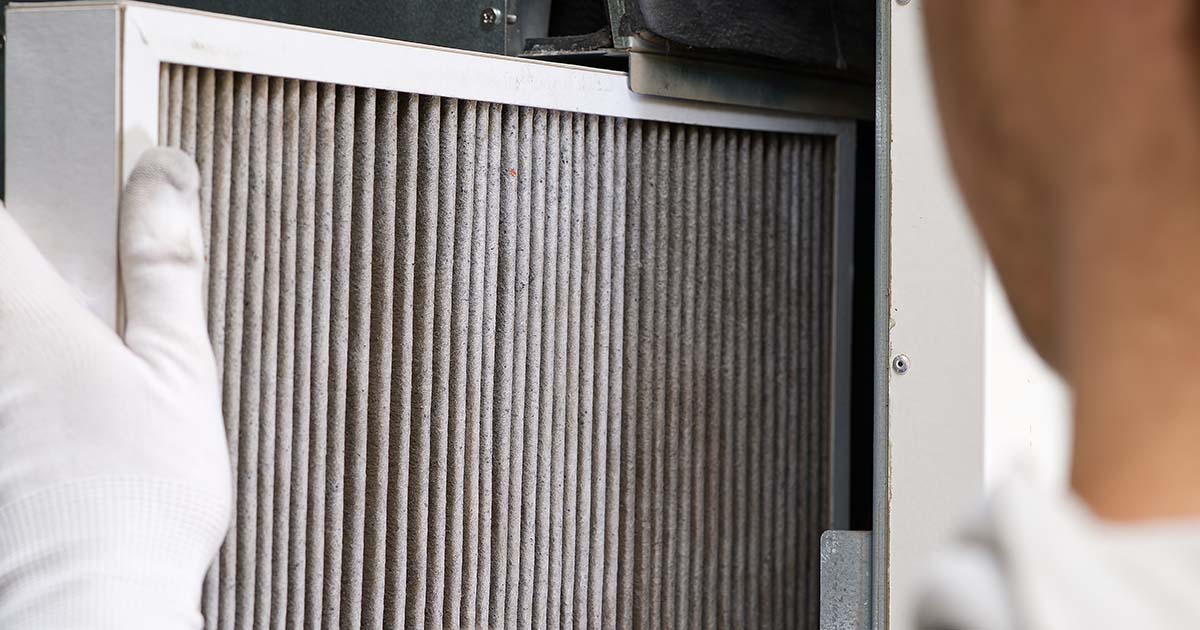 Person removing dirty furnace filter.