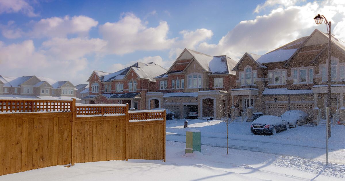 Subdivision in winter, houses and driveways covered in snow.