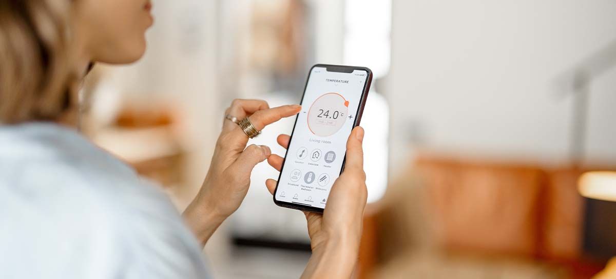 Woman on phone monitoring indoor air quality.