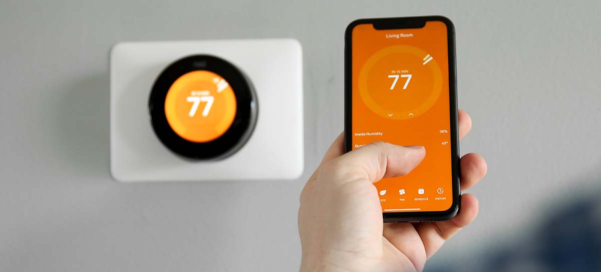 Smart thermostat on wall and programmed on phone.
